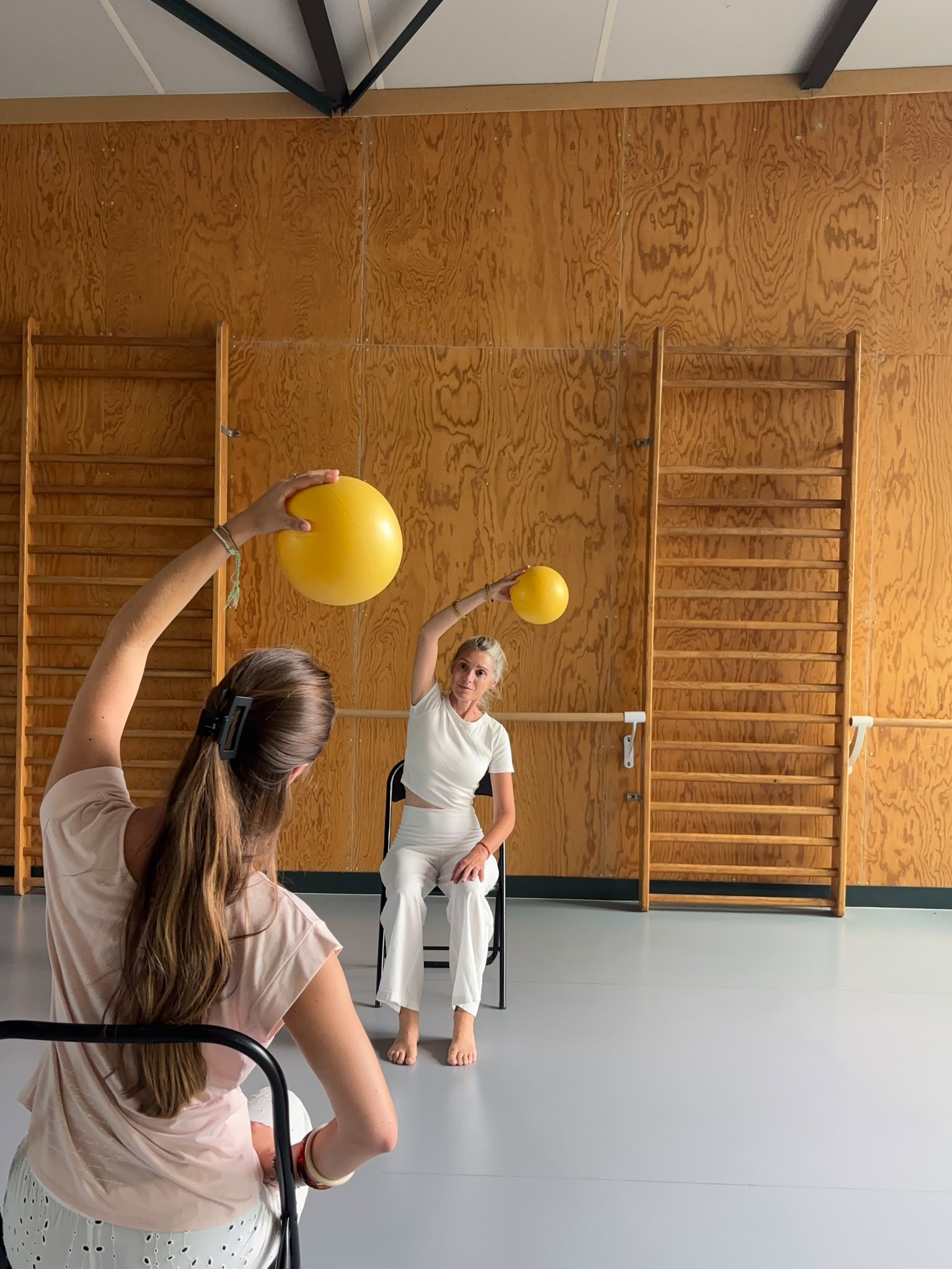 Exercice avec ballons en position assise lors d’une séance d’activité physique adaptée